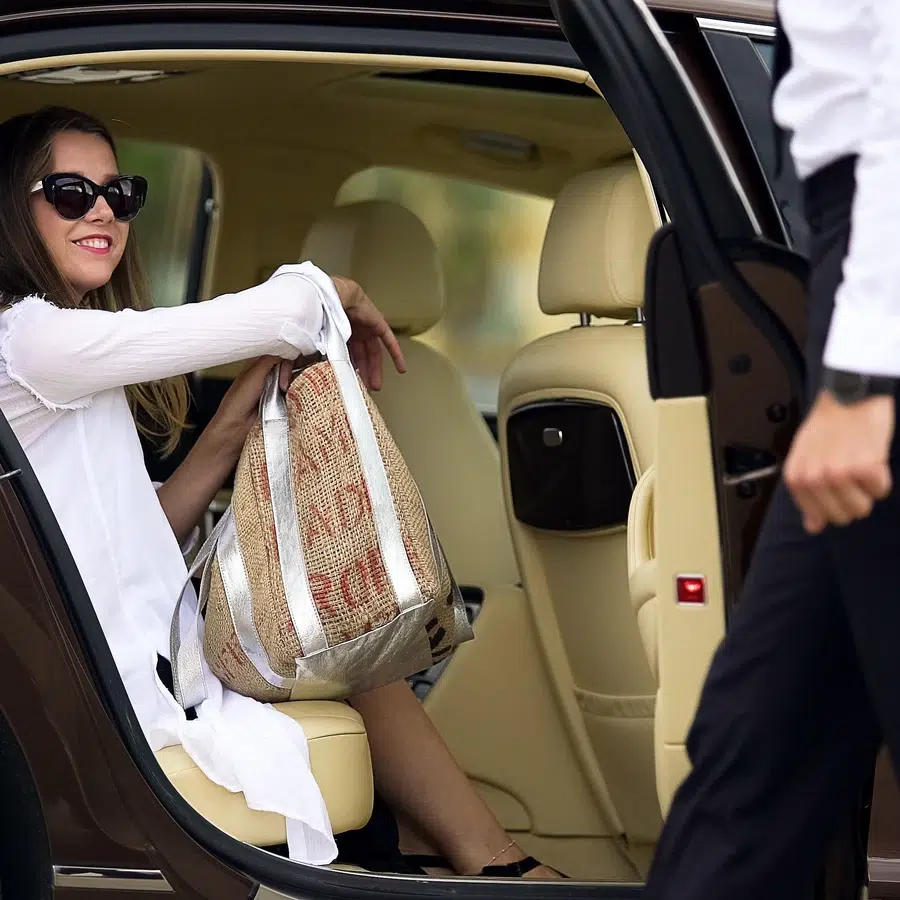 Femme souriante dans une voiture avec un sac